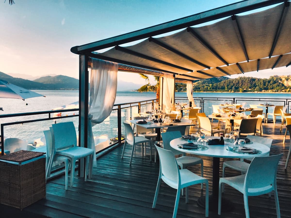 Terrasse du restaurant au-dessus de l'eau, tables dressées sous la pergola