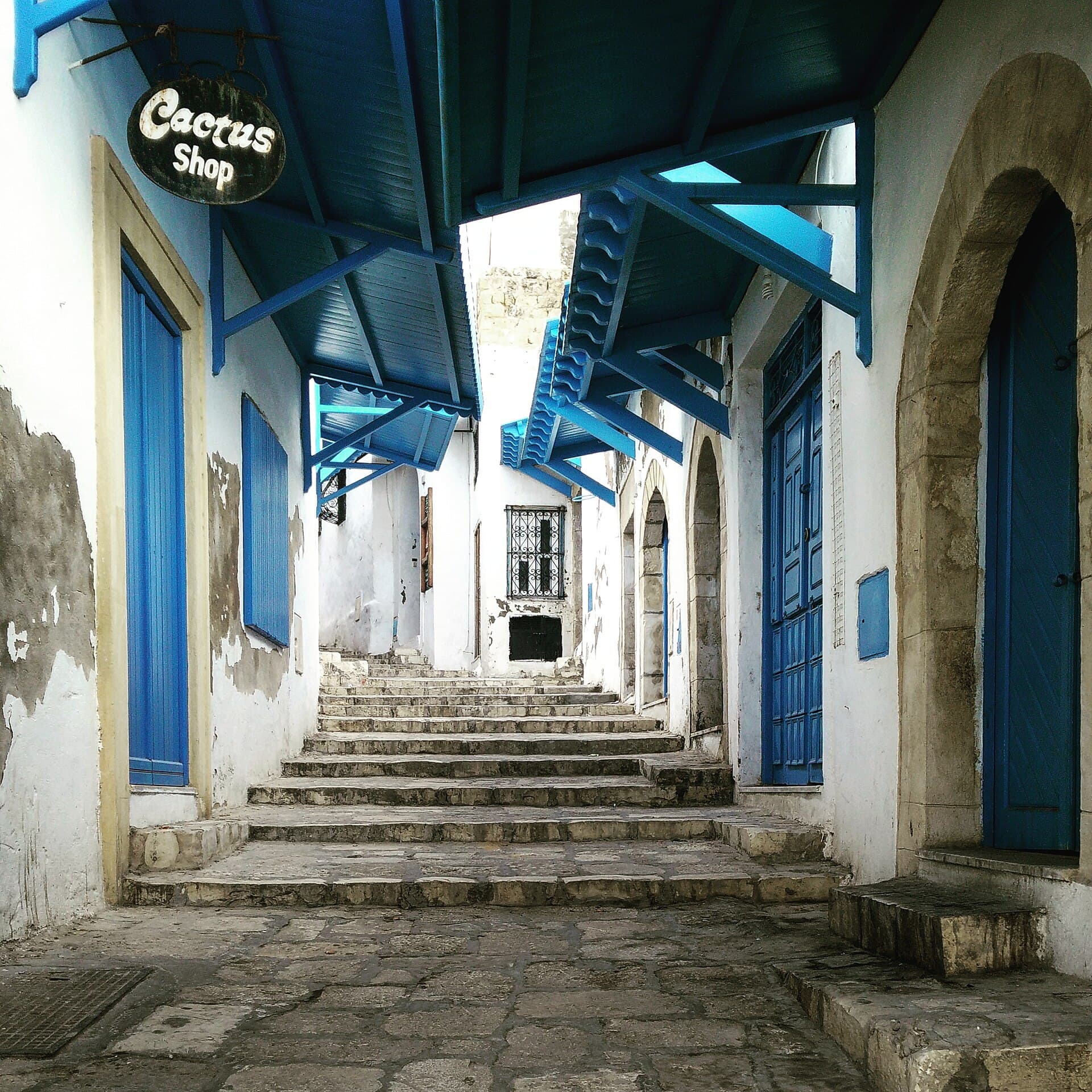 Escaliers et auvents bleus d'une ruelle blanche de la médina de Sousse