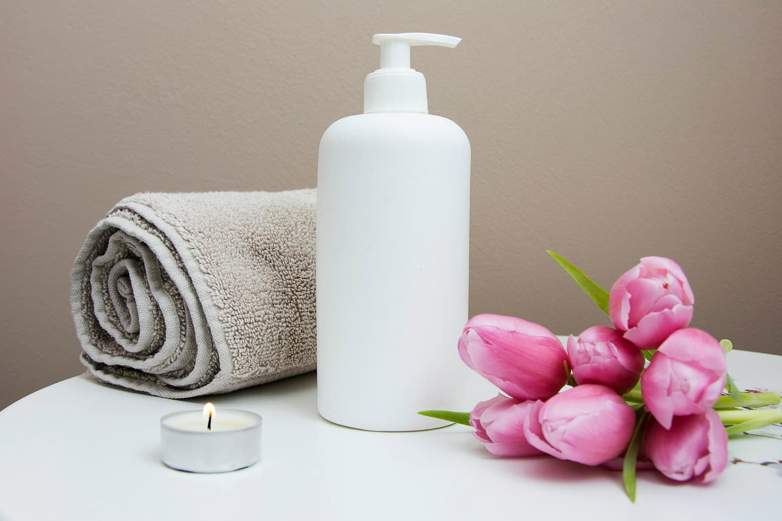 Serviette roulée, bougie et fleurs fraîches dans une cabine du Spa Azur